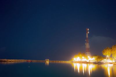 Reflection of illuminated trees in water at night