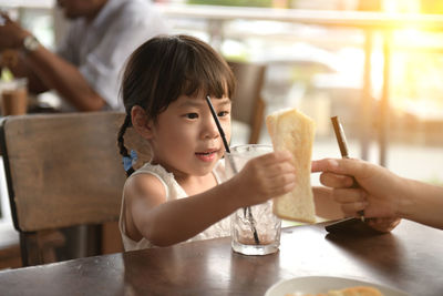 Portrait of woman holding ice cream in restaurant