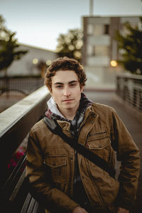 Portrait of young man standing on footbridge