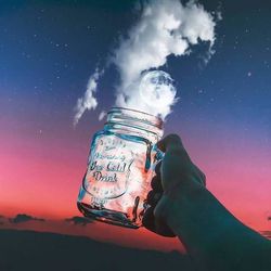 Digital composite image of hand holding hands against sky at night