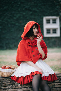 Young woman holding apple and sitting on bench