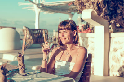 Portrait of a smiling young woman drinking glass