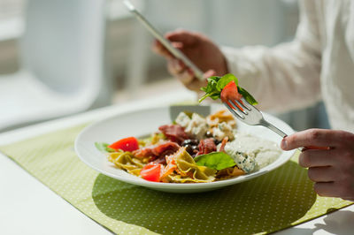 Midsection of person holding food in bowl