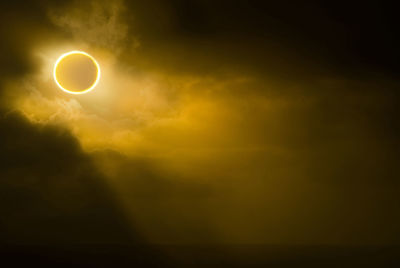 Low angle view of solar eclipse in sky during foggy weather
