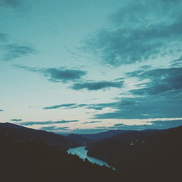 sky, mountain, cloud - sky, scenics, tranquil scene, beauty in nature, tranquility, cloudy, mountain range, nature, cloud, blue, landscape, weather, built structure, outdoors, idyllic, building exterior, dusk, architecture