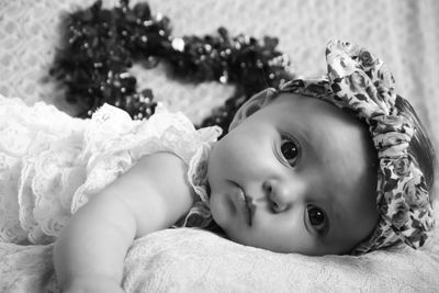 Close-up of cute baby lying on bed at home