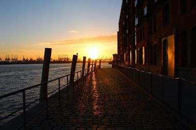 Canal amidst buildings against sky during sunset