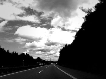 Empty road against cloudy sky