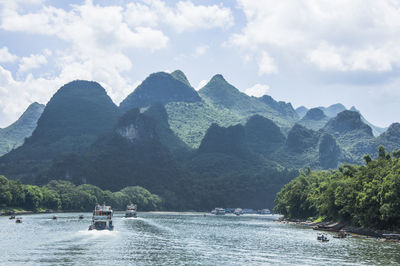 Boat on river against mountains