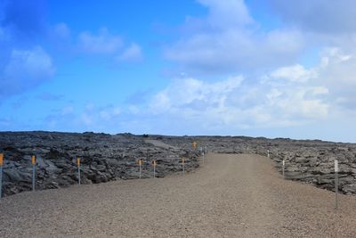 Scenic view of beach against cloudy sky