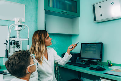 Smiling ophthalmologist doing eye test of boy