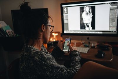 Woman using phone while sitting on table