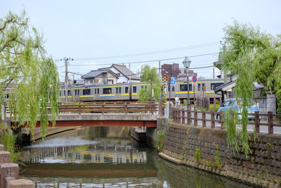 Footbridge over canal amidst buildings against sky