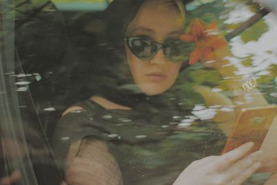 Portrait of young woman seen through glass window