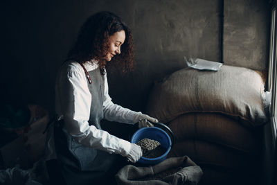 Side view of woman sitting on sofa at home