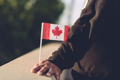 Midsection of man with flag standing outdoors