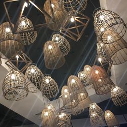 Low angle view of illuminated pendant lights hanging from ceiling