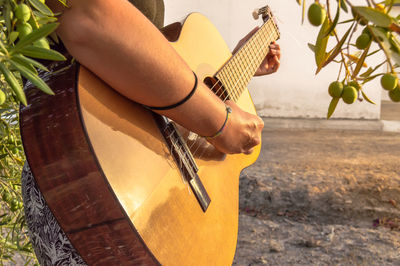 Midsection of woman playing guitar