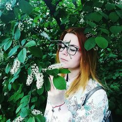 Young woman wearing eyeglasses and tree