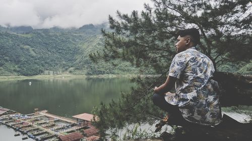 Side view of man standing by lake