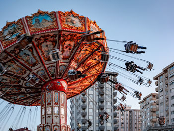 Low angle view of a carousel spinning in the middle of a city.