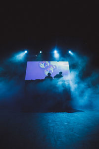 Illuminated lighting equipment against blue sky at night