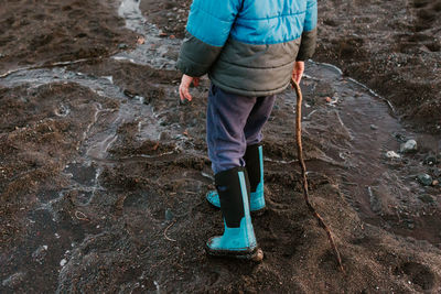 Low section of boy walking at beach