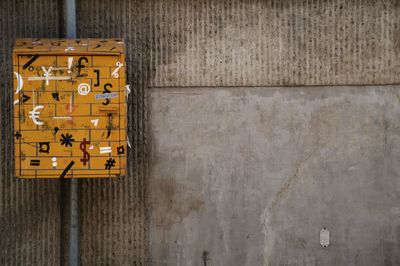 Yellow mailbox against wall