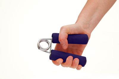 Close-up of hand holding hands over white background