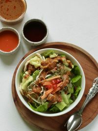 High  angle view of indonesian spicy salad topped with peanut sauce on the table.