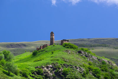 Tower in the mountains. built structure on landscape against blue sky