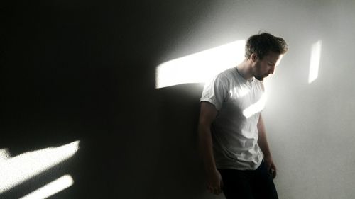 Rear view of woman standing in front of wall