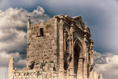 Low angle view of old building against cloudy sky