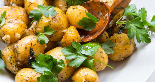 High angle view of prepared potatoes with cilantro in plate