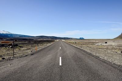 Road amidst landscape against clear blue sky