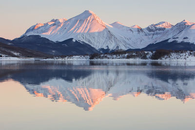 Snowcapped mountains reflecting on lake