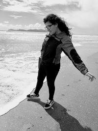 Woman standing on beach against sea