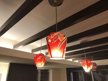 Low angle view of illuminated pendant lights hanging from ceiling