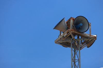 Low angle view of communications tower against clear blue sky