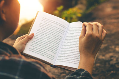 Cropped image of hand holding book