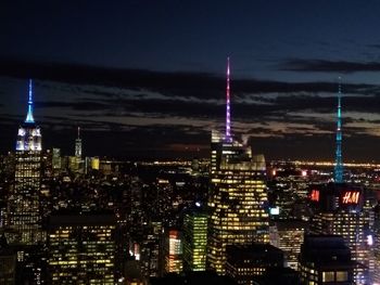 Illuminated cityscape against sky at night