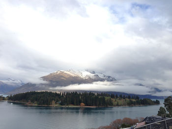 Scenic view of lake by mountains against sky