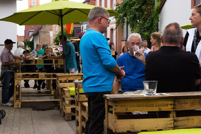 Group of people relaxing in front of building