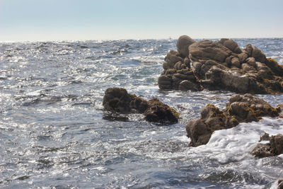 Rocks in sea against sky