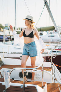 Woman standing by boat on the sailboat