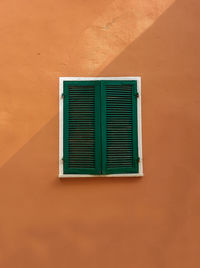 Closed window on brown wall