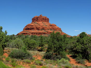 Rock formations on landscape against clear blue sky