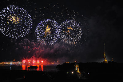 Firework display over river in city at night