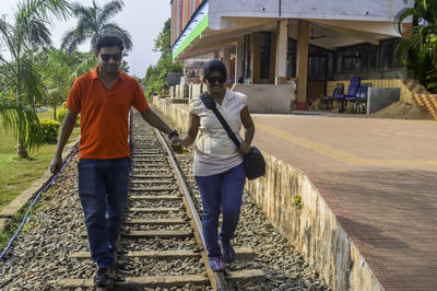 Rear view of couple walking on road