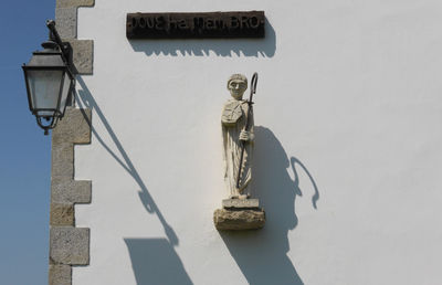 Statue mounted on white wall